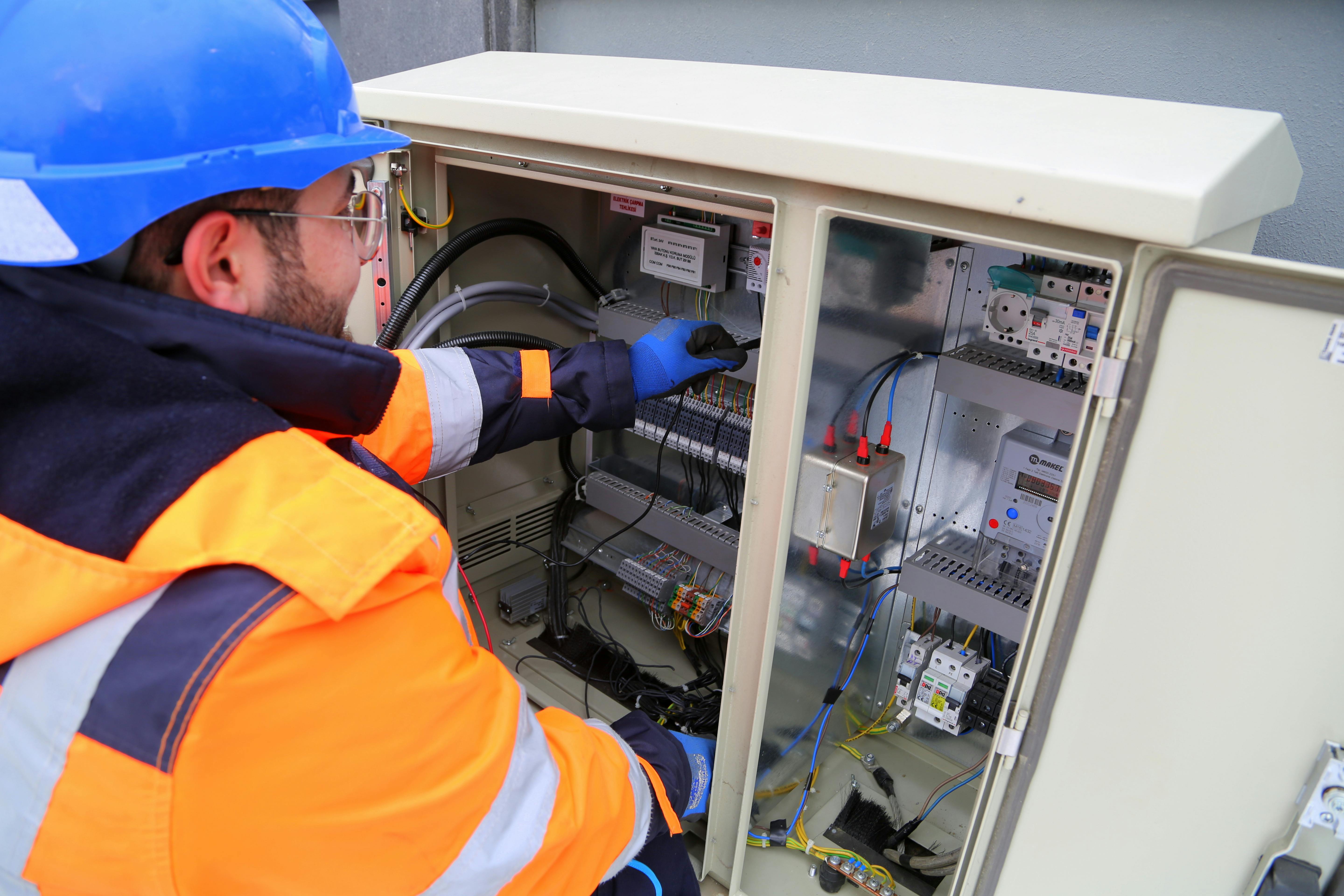 Commissioning technician inspecting an electrical control panel